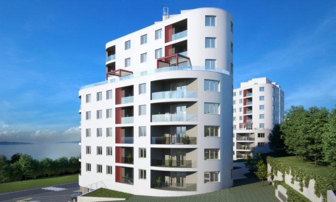 Moderna bijela stambena zgrada s zakrivljenim balkonima i crvenim detaljima, na pozadini plavog neba, s drvećem i drugom zgradom u pozadini.